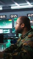 Vertical Air force officer and colleague performing tactical level surveillance in command post. Team of military specialists doing brainstorming, using radar equipment to look at assault zones, camera B video