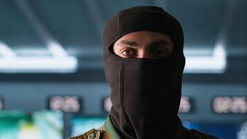 Portrait of terrorist loading gun, attacking enemy command center. Close up of masked insurgent reloading pistol during enemy base assault hijacking in guerilla warfare armed conflict, camera A video