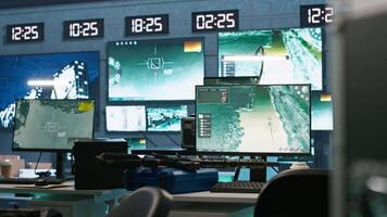 Secure room in army governmental facility operating as military command post and surveillance monitoring center, filled with digital equipment. Empty military base of operations with radar systems video