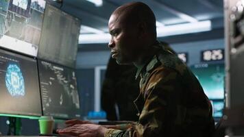 Army software developer employing AI tech in military planning and decision making. African american IT specialist uses artificial intelligence to enhance combat operational capabilities, camera A video