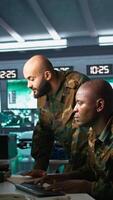 Vertical Army telecommunications operators using radio and satellite gear, inputting data on systems. Military dispatchers managing communications networks, typing on keyboard, camera B video