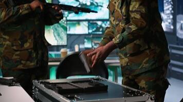 Team of army soldiers in command center packing weapons able to engage targets at extended range. Military units reloading gun cartridge, preparing for enemy assault mission, camera A video