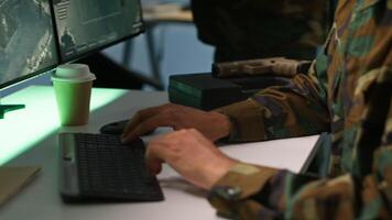 Special forces military agent working in control room, analyzing aerial reconnaissance data. Close up of intelligence corps expert controlling drones attacking strategic targets, camera A video