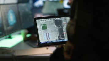Soldier in military HQ base using digital tablet to gather information on enemy troops. Close up shot of officer using software on device to do assessment of enemy vulnerabilities, camera A video