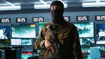 Terrorist occupying enemy base of operations, conducting guerilla warfare. Rebel forces hijacker with firearm in hidden war room starting offensive against opponents, camera A video