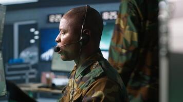 Army telecommunication systems operator using radio gear, providing combat support, doing patriotic duty. African american military dispatcher managing communications networks, camera A video