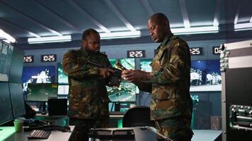 Operatives conducing special operation, loading pistol, preparing to attack enemy troops. Close up of military unit in command center packing handgun for assault mission, camera B video