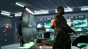 Soldier doing tasks in military base, doing surveillance with digital radar equipment, operating missile systems. Middle Eastern man monitoring army HQ CCTV for any unauthorized activity, camera B video