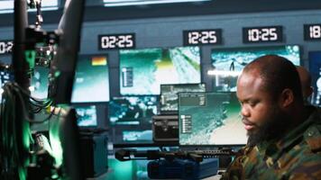 Military agents in war room look at intel folder files on enemy battle formation. Intelligence agency professionals read mission case file to collect data on opponents strategy, camera A video