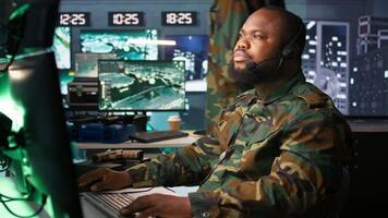 Army telecommunication systems operator using radio and satellite gear, providing combat support. Military dispatcher managing communications networks, looking at screens, camera B video