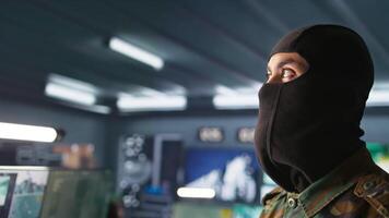 ritratto di terrorista Caricamento in corso pistola, attaccare nemico comando centro. vicino su di mascherato ribelle ricaricare pistola durante nemico base assalto dirottamento nel guerriglia guerra armato conflitto, telecamera B video