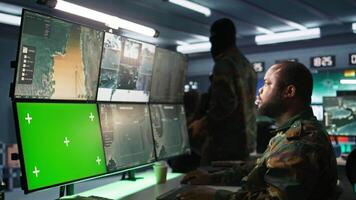 Soldier in military HQ base using green screen equipment to gather information on enemy troops. Officer using chroma key devices to do assessment of enemy vulnerabilities, camera B video