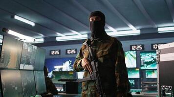 Terrorist occupying enemy base of operations, conducting guerilla warfare. Rebel forces hijacker with firearm in hidden war room starting offensive against opponents, camera B video