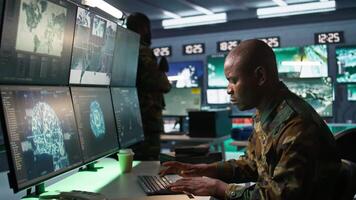Army software developer employing AI tech in military planning and decision making. African american IT specialist uses artificial intelligence to enhance combat operational capabilities, camera B video