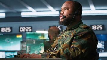 Army telecommunication systems operator providing combat support using gathered information on enemy troops. Military dispatcher managing communications networks in base of operations, camera A video