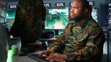 Counterintelligence specialist in military HQ base gathering information on enemy troops. African american agent in base of operations doing assessment of enemy vulnerabilities, tracking, camera B video