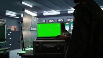 Army telecommunication systems operator using green screen gear, providing combat support. Military dispatcher managing communications networks with mockup laptop, camera B video