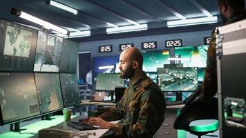 Military agent working in control room, analyzing aerial reconnaissance data. Intelligence corps agent controlling drones attacking strategic targets, camera B video
