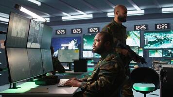 Army operative in command center analyzing surveillance data during global warfare. Intelligence agent in base of operations completes mission during World War 3 geopolitical operation, camera B video