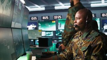 Army telecommunication systems operator using radio gear, providing combat support, doing patriotic duty. African american military dispatcher managing communications networks, camera B video