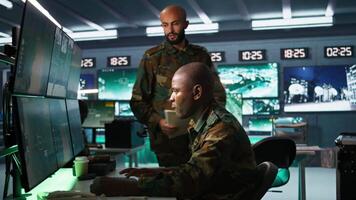 team av militär kommenderar i kommando Centrum se på intel mapp filer på fiende slåss bildning. intelligens kår kollegor läsa uppdrag fall fil till samla data på motståndare strategi, kamera b video