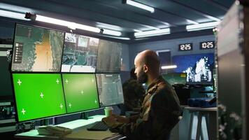 Military agent working in control room, using isolated screen software on laptop, analyzing aerial reconnaissance data. Intelligence corps expert controlling drones with mockup notebook, camera B video