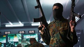 Terrorist holding rifles attacking enemy command post, looking around for threats. Insurgent inspecting room during enemy base assault hijacking in guerilla warfare armed conflict, camera B video