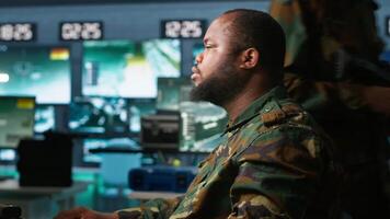 Soldiers working in governmental facility, doing surveillance with digital radar equipment, operating missile systems. Man monitoring army HQ CCTV for any unauthorized activity, camera A video