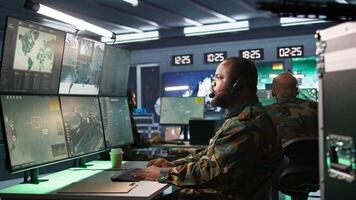 Army telecommunication systems operator providing combat support using gathered information on enemy troops. Military dispatcher managing communications networks in base of operations, camera B video