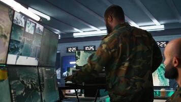 Air force officer performing tactical level surveillance in command room using laptop. Close up of military specialist in base of operations using radar on notebook to look at assault zones, camera B video