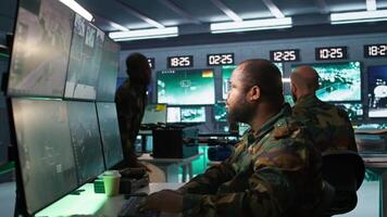 Air force officer and colleague performing tactical level surveillance in command post. Team of military specialists doing brainstorming, using radar equipment to look at assault zones, camera B video
