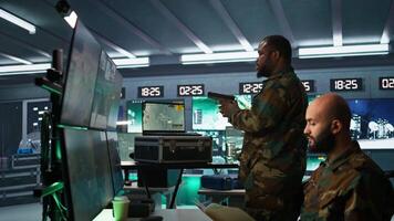 Military soldier wearing camo uniform in mission control center, overseeing national safety operations using laptop. Army expert examining data in monitoring room command center, camera B video