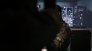 Officer doing tasks in military base, planning, analyzing and gathering information on enemy troops. Agent in base of operations doing assessment of enemy vulnerabilities, tracking, camera B video