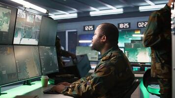 Soldier doing tasks in military base, using radar, intercepting and destroying ballistic rockets. Man monitoring army HQ CCTV for any unauthorized activity, tracking missiles, camera B video