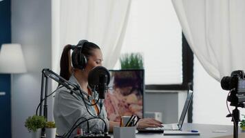 Internet live radio show host typing on computer while talking to audience. Famous digital content creator chatting with public on live chat while speaking on modern microphone. video