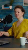 Vertical . Portrait of young vlogger working in cozy studio, smiling at camera ready to start new podcast show. On-air online production internet broadcast show host streaming web content record digital blog video