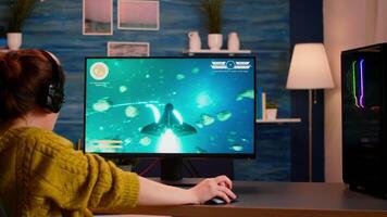 Back view of happy pro gamer winning space shooter game, raising hand celebrating, Virtual shooter game in cyberspace, esports player playing on computer game sitting at home, gaming tournament video