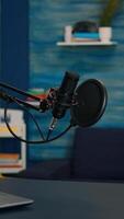 Vertical . Station for recording and speaking during podcast in night in empty livin room studio. Influencer recording social media content with production microphone, digital web internet streaming station video