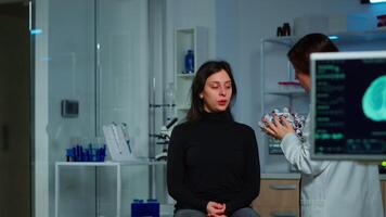 Asistance of neurological doctor putting eeg headset on patient head scaning brain functions, descovering diagnosis of disease. Team of scientists researchers working late night in neurology clinic video