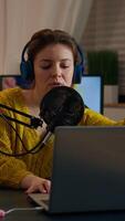 Vertical . Blogger opening laptop starting to talk with followers recording new podcast at home studio. On-air online production internet broadcast show host streaming live content, recording digital vlog video