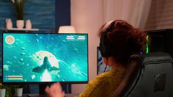 Joyful player celebrates victory winning space shooter online game on powerful personal computer. Online streaming cyber performing during gaming tournament using technology network wireless video