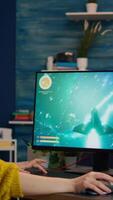 Vertical . Expert woman gamer playing space shooter game on powerful PC. Virtual shooter game championship in cyberspace, esports player performing on computer in stylish room during gaming tournament video