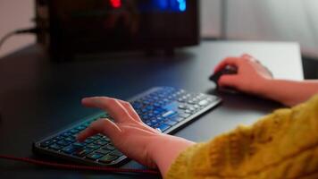 Close-up on woman hands gamer playing game using RGB keyboard during virtual championship in cyberspace. Online streaming cyber performing on powerful personal computer during gaming tournament video