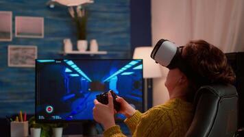 Experienced gamer wearing VR playing at home game using wireless controller, relaxing at night. Online streaming cyber performing on powerful personal computer during gaming tournament video