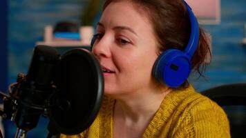 Famous vlogger making an online podcast recording for virtual show. Influencer using headphones speaking at microphone for radio program, On-air production internet broadcast show host streaming video