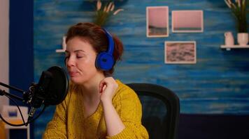 Vlogger checking microphone sound with finger, starting livestreaming sitting in home podcast studio. On-air online production internet broadcast show host streaming live content for social media video