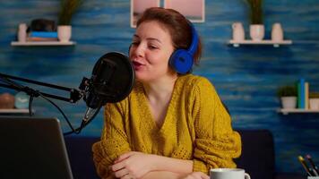 Woman vlogger recording to camera tutorial about lifestyle in home podcast studio during livestreaming. On-air online production internet broadcast show host streaming live content for social media video