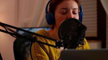 Close up of professional influencer making podcast from home studio. On-air online production internet broadcast show host streaming live content for social media using internet web video