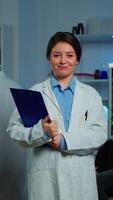 Vertical . Portrait of scientist neurologist researcher looking at camera smiling while coworker discussing with patient in background about brain functions, nervous system, tomography scan working in laboratory video