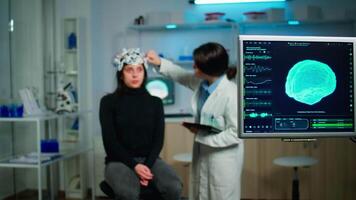 Doctor analysing brain scan using tablet, examining evolution of disease working in neurological laboratory. Monitoring nervous system functions using high tech in technologically advanced lab office video